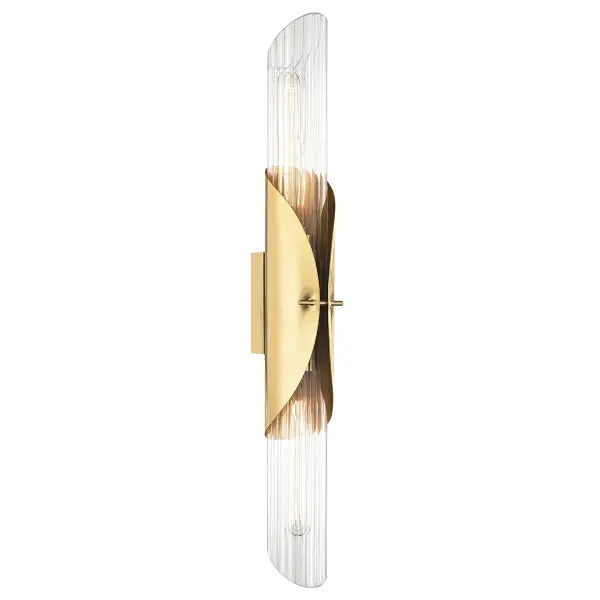 The Lefferts wall sconce combines classic brass warmth with contemporary clean lines. Its slender 26-inch vertical profile and clear optic glass create sophisticated ambient lighting ideal for flanking mirrors or illuminating hallways.