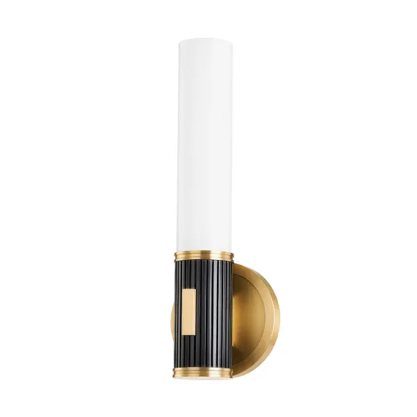 The Crewe wall sconce combines refined simplicity with sophisticated contrast. Its tubular design features a medallion-style backplate in aged brass paired with a striking fluted black bronze arm, creating visual interest without overwhelming.