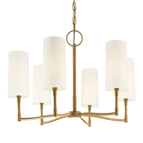 The Dillon chandelier combines transitional elegance with contemporary clean lines. Six candelabra lights with off-white linen shades provide warm, diffused illumination. The aged brass finish adds timeless sophistication.