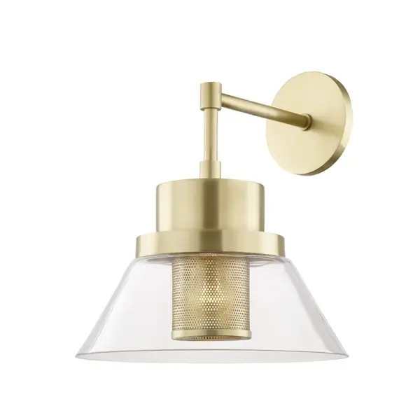 The Paoli wall sconce reimagines the classic wharf light with refined minimalism. Its perforated metal shade and aged brass finish create visual interest while maintaining clean lines. Perfect for adding industrial charm without overwhelming a space.