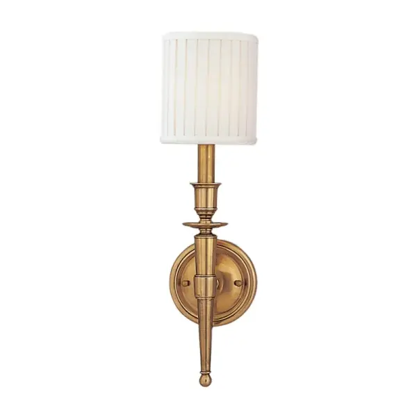 The Abington wall sconce combines classic proportions with contemporary simplicity. Its aged brass finish and faux silk shade create warm, diffused light perfect for intimate spaces. Compact profile works in tight hallways.