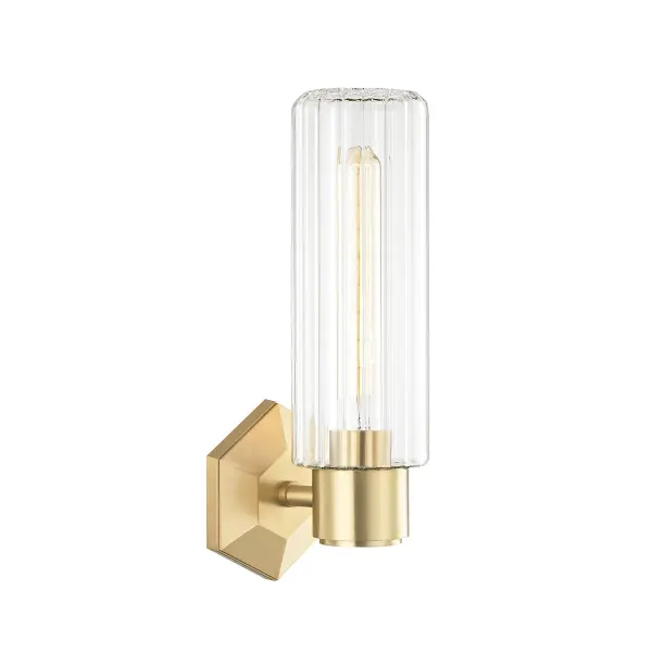 The Roebling sconce elevates the classic wall sconce with decorative faceting and fluted glass. Its gem-like faceted backplate creates an unexpected focal point, while the tube shade provides functional lighting with graphic appeal.