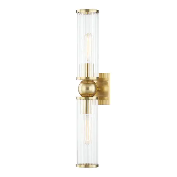 The Malone wall sconce combines classic brass warmth with contemporary clean lines. Its vertical orientation and clear glass shades make it ideal for flanking mirrors or creating symmetrical lighting arrangements in bathrooms and hallways.
