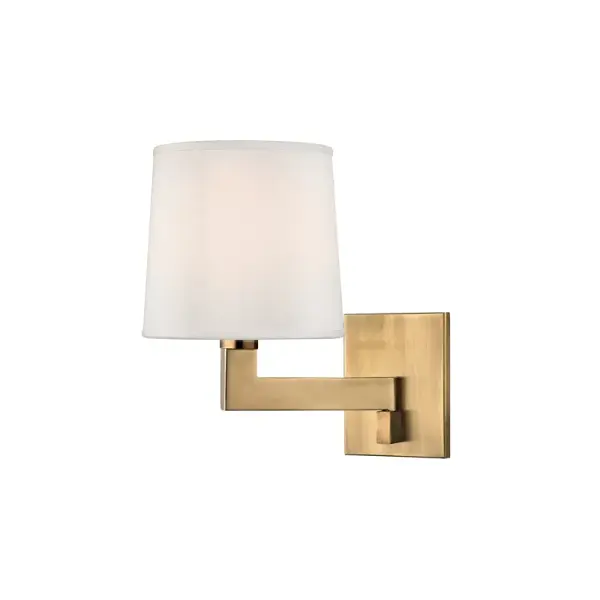 The Fairport wall sconce combines classic elegance with contemporary simplicity. Its aged brass finish and faux silk shade create warm, inviting illumination perfect for intimate spaces.