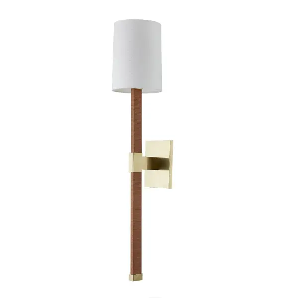 The Minnetonka wall sconce brings nautical charm through its distinctive rattan wrap and elongated torch silhouette. Aged brass accents provide refined contrast to natural textures, creating an artful blend of rustic and sophisticated design.