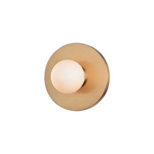 The Taft is a petite, energy-efficient wall sconce that delivers modern sophistication in a compact footprint. Its aged brass finish and opal matte shade create soft, diffused light ideal for intimate spaces.