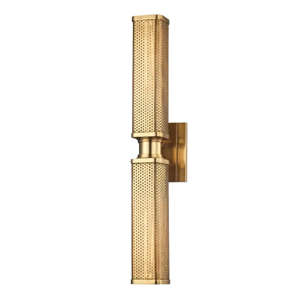 The Gibbs sconce masterfully blends Machine Age aesthetics with human warmth through its perforated metal shade and exposed-filament design. The soft square profile and quality aged brass finish elevate this fixture beyond typical industrial lighting.