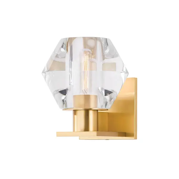 The Cooperstown sconce features a distinctive diamond-shaped crystal shade that creates stunning light diffusion. The chunky Aged Brass metalwork adds warmth and sophistication, making it ideal for upscale residential and hospitality settings.