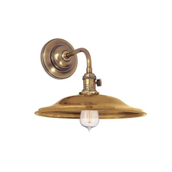 The Heirloom wall sconce combines traditional craftsmanship with versatile styling. Its aged brass finish and compact 10-inch width make it ideal for flanking mirrors or creating ambient lighting in smaller spaces.