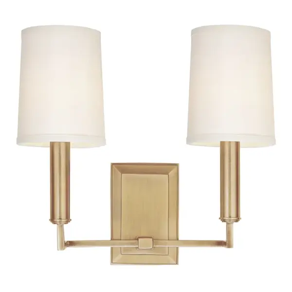 The Clinton wall sconce reimagines traditional candlestick styling with modern stepped circular rings and a sleek tapered shade. Its compact 11-inch profile and warm aged brass finish make it ideal for bathrooms and hallways.