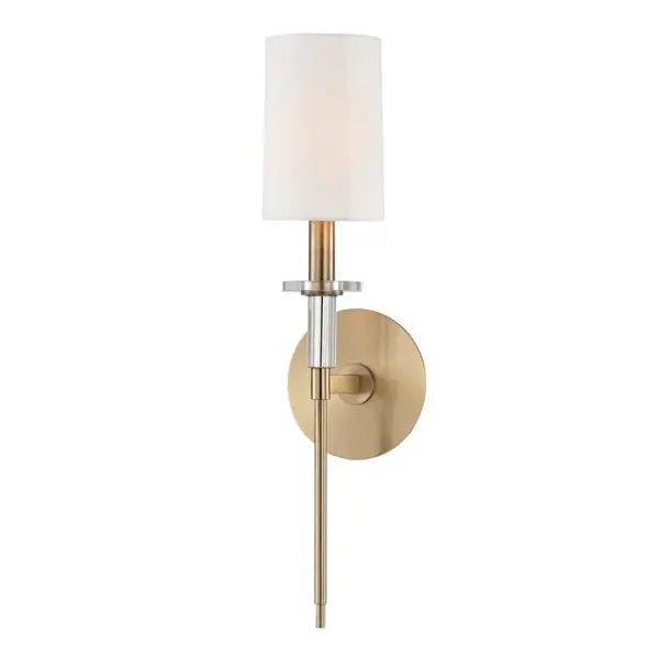 The Amherst wall sconce combines classic proportions with contemporary simplicity. Its aged brass finish and faux silk shade create warm, diffused light perfect for intimate spaces. Compact at 5" wide, it fits narrow hallways and powder rooms beautifully.