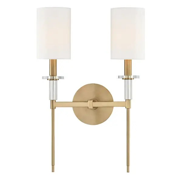 The Amherst wall sconce combines traditional craftsmanship with transitional appeal. Its aged brass finish and faux silk shades create warm, ambient lighting perfect for residential and hospitality settings.