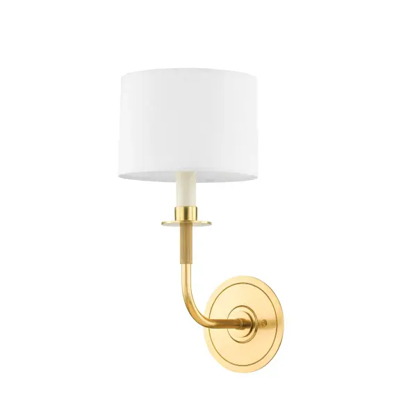 Paramus updates traditional sconce design with elongated proportions and refined details. The upward-extending arm supports a candle sleeve topped with a white linen drum shade, creating soft, diffused light. Aged brass finish adds warmth.
