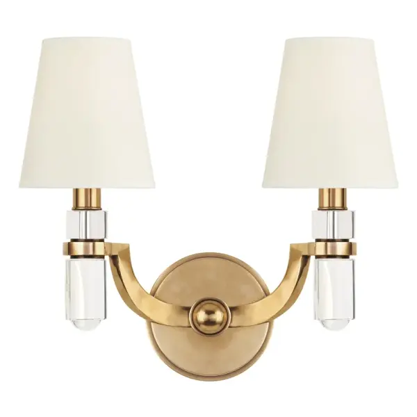 The Dayton wall sconce combines timeless design with contemporary functionality. Its aged brass finish and faux silk shades create warm, inviting illumination perfect for residential and hospitality settings.