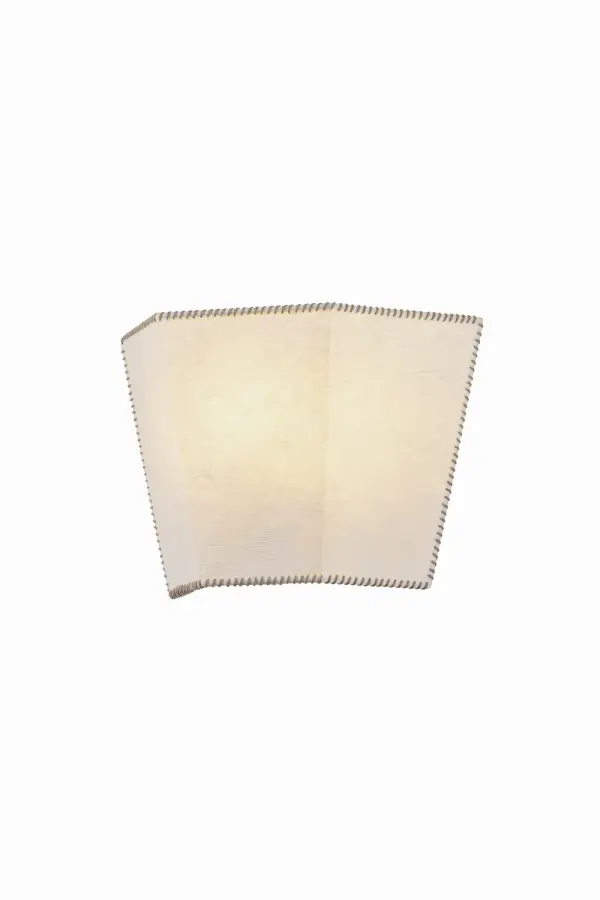 The Celmins wall sconce brings quiet architectural beauty through handcrafted paper construction. Its angular shade features distinctive mushroom-hued whipstitching that adds warmth and texture to modern interiors.