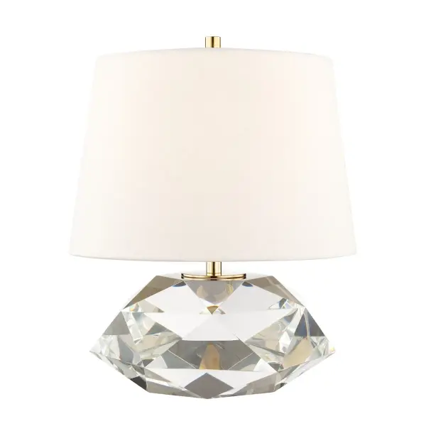 The Henley table lamp combines a substantial multifaceted crystal base with aged brass accents and a Belgium linen shade. Its visual weight anchors spaces while providing sophisticated illumination. The full-range dimmer offers lighting flexibility.