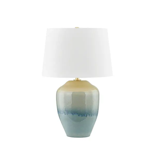 This Hudson Valley table lamp showcases a striking ceramic body with an emerald tide crackle glaze finish, complemented by aged brass accents. The artisanal ceramic work creates visual depth and texture.