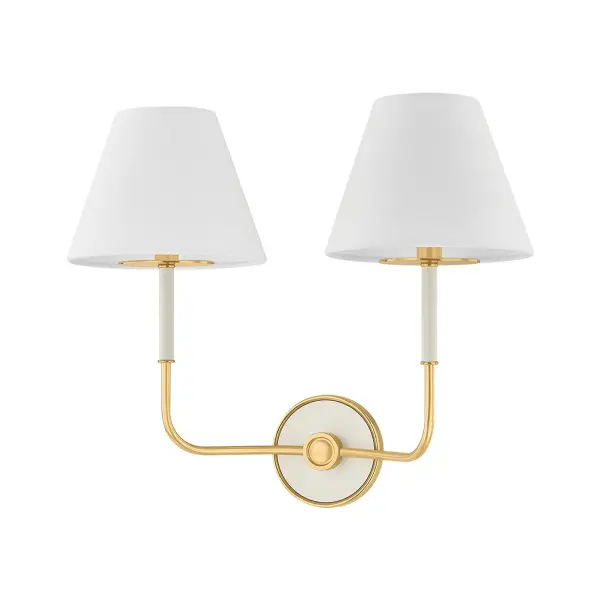 This Hudson Valley wall sconce combines aged brass metalwork with off-white fabric shades for a refined, versatile look. The two-light design provides balanced illumination ideal for flanking mirrors or creating symmetry in hallways and bedrooms.