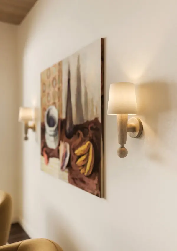 The Nola Wall Sconce brings understated elegance through handcarved cerused whitewash wood and a simple linen shade. Inspired by iconic Scandinavian designers, each piece features unique wood grain patterns for authentic artisanal character.