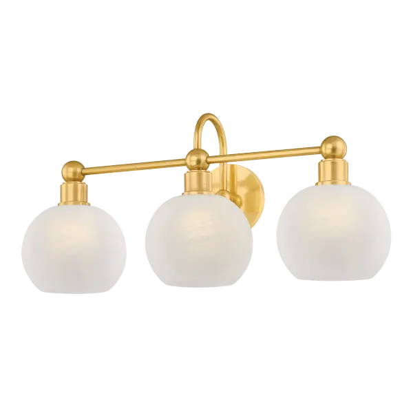 The Jerica bath light brings serene sophistication to bathroom spaces with its harmonious circular forms and decorative sphere details. Matte cloud glass globes provide soft, flattering illumination while the Aged Brass finish adds warmth and elegance. - alternate view