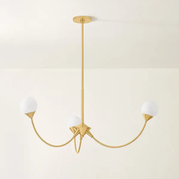 The Natasha Chandelier balances nostalgic elegance with contemporary design through swooping arches and cloud glass orbs. Its Aged Brass finish and sparse yet dramatic silhouette create a fresh, daring statement piece. - alternate view