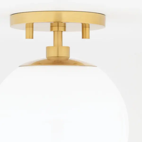 The Stella Semi Flush brings timeless mid-century modern design to any space with its frosted glass globe and sleek aged brass finish. Perfect for rooms with lower ceilings, this fixture offers soft, diffused lighting. - alternate view