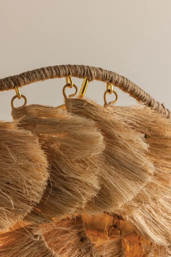 The Daria chandelier transforms natural banana fiber into a stunning statement piece with its undulating wrapped frame and shaggy textured layers. The Aged Brass finish adds refined elegance to this handcrafted design. - alternate view