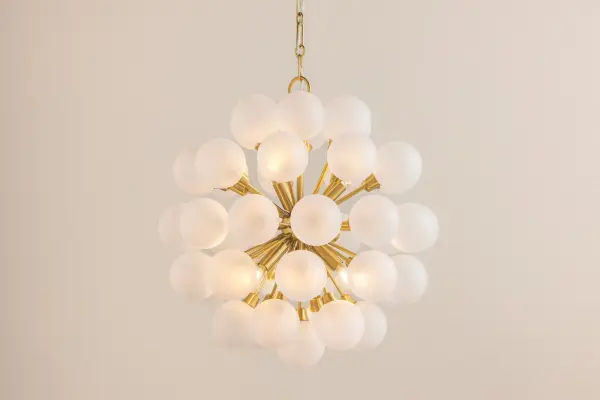 The Antoneta Chandelier brings mid-century modern flair with its Sputnik-inspired design. Six clear etched glass globes create a striking geometric silhouette, while the Aged Brass finish adds warmth and sophistication to any space. - alternate view