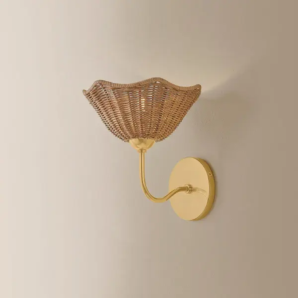 The Kehlani Wall Sconce brings organic texture and warmth through its handcrafted wicker shade and aged brass metalwork. Each piece is unique, offering an artisanal alternative to traditional wall lighting with coastal-inspired charm. - alternate view