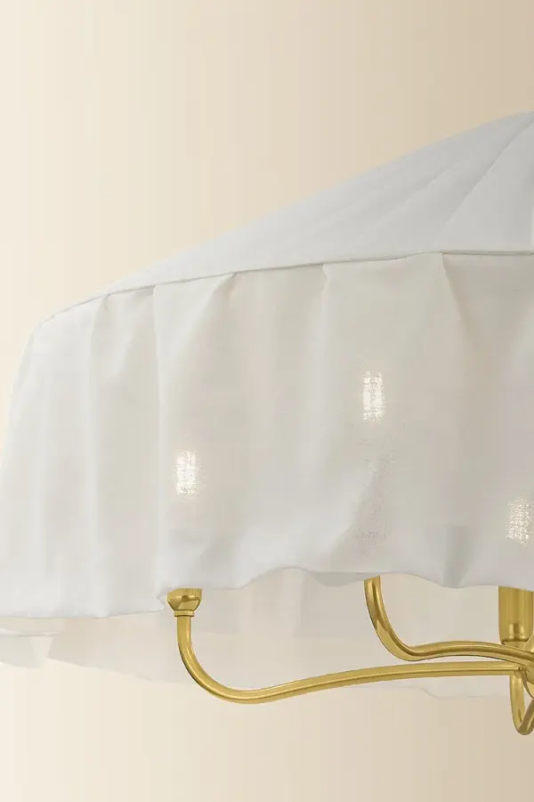 The Shivonne Chandelier blends modernist design with soft materiality, featuring an ivory linen shade that drapes elegantly around a candle cluster. Aged Brass finish adds vintage warmth while maintaining contemporary appeal. - alternate view