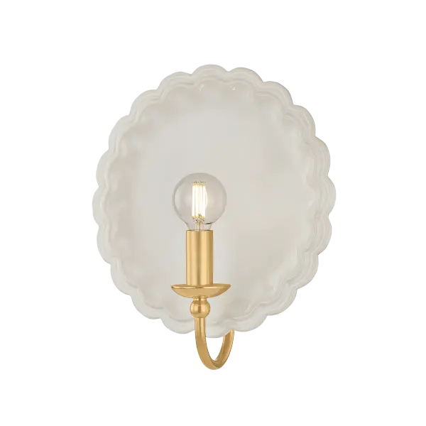 The Paulette sconce blends hand-sculpted ceramic artistry with aged brass metalwork for a sophisticated transitional look. Its scalloped backplate and gooseneck arm create an elegant focal point perfect for intimate spaces.