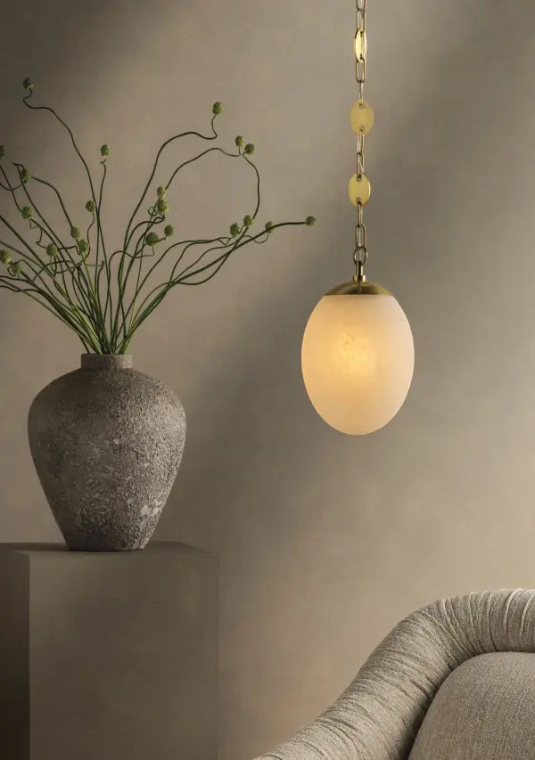 A specialty suspension and organic shaping elevate the Nell pendant into jewelry for the ceiling. Finished in Aged Brass, the chain's delicate discs alternate with classic loops as they guide the eye to an elongated etched cloud glass globe. Available in two sizes, this single-light fixture lends itself beautifully to repetition, whether aligned along an island or gathered in a cluster to form an artful installation. Part of our Hilary Matt x Mitzi Tastemakers collection. Collection: Nell Designer: Hilary Matt Finish: Aged Brass Glass: Matte Cloud Width: 12.00" Height: 18.50" Weight: 6.38 lb Chain: 54" Canopy: 4.75"x0.50" Number of Bulbs: 1 Maximum Wattage: 25.00 W Bulb Type: A21 Bulb Base: E26 Medium Voltage: 120.00 V Material: Steel Country of Origin: VN Safety Listing: UL/cUL Safety Rating: Damp Manufacturer Warranty: 1 Year Limited Manufacturer Spec Sheet Instructions - alternate view