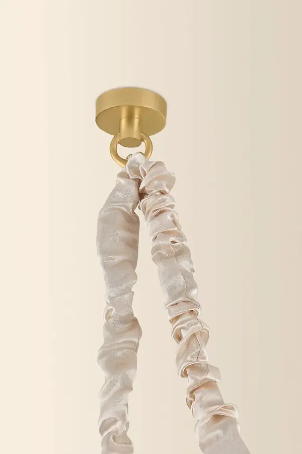 Imbued with a sense of Parisian romance, the Remi family's use of textiles and artisanal glasswork is nothing short of ethereal. A white silk sleeve gathers over the suspension chain, supporting a clear cloud glass globe that floats in space like a drop of rain. The single-light pendant format serves as a delicate focal point, while the three-light swagged chandelier emits illumination to fill an entire room. Accents of Aged Brass unite each element of Remi. Part of our Hilary Matt x Mitzi Tastemakers collection. Collection: Remi Designer: Hilary Matt Finish: Aged Brass Glass: Clear Cloud Width: 67.50" Height: 16.25" Weight: 18.11 lb Chain: 72" Canopy: 5.00"x1.00" Number of Bulbs: 3 Maximum Wattage: 15.00 W Bulb Type: G25 Bulb Base: E26 Medium Voltage: 120.00 V Material: Steel Country of Origin: VN Safety Listing: UL/cUL Safety Rating: Damp Manufacturer Warranty: 1 Year Limited Manufacturer Spec Sheet Instructions - alternate view
