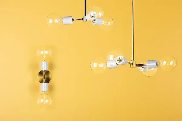 The Asime Wall Sconce combines polished metal arms with natural marble bulb bases for a sophisticated, contemporary look. Its exposed globe bulbs provide bright, clear illumination while the mixed materials add textural interest. - alternate view