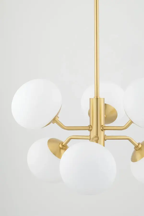 The Estee Chandelier reimagines the classic globe chandelier with unique oblong shades and aged brass finish. Its mid-century inspired design brings personality and modern flair to dining rooms and living spaces. - alternate view