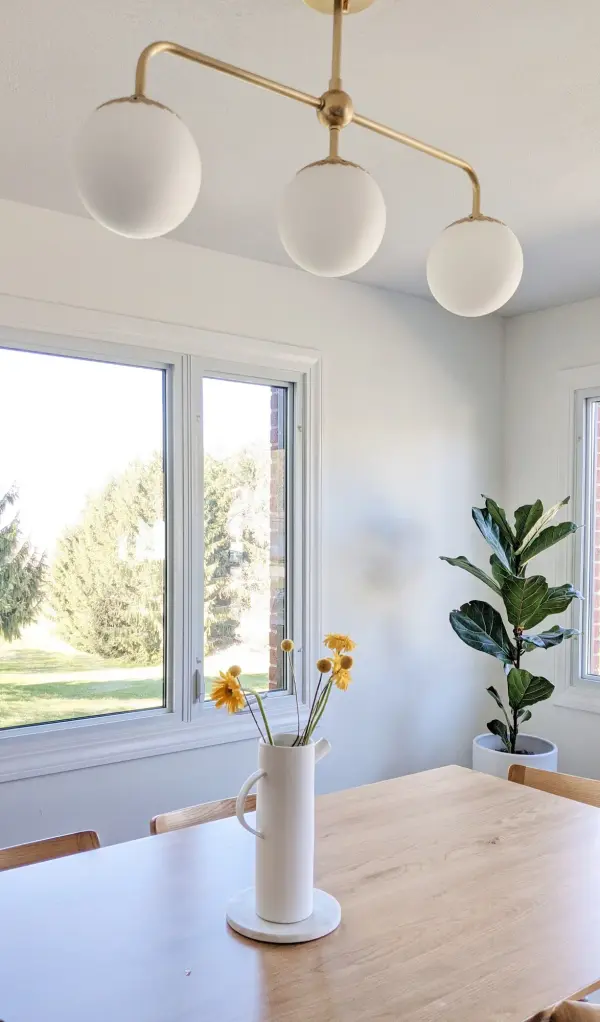 The Paige Linear Chandelier combines contemporary design with warm aged brass tones, creating a sophisticated focal point. Its linear form makes it perfect for dining tables and kitchen islands, while glass globes provide soft, ambient lighting. - alternate view