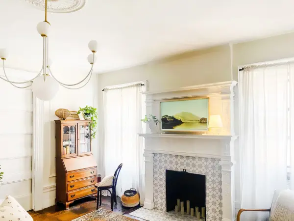 The Coco Chandelier combines aged brass metalwork with crisp white fabric shades for a sophisticated transitional look. Its balanced proportions and warm finish make it versatile across traditional and contemporary spaces. - alternate view