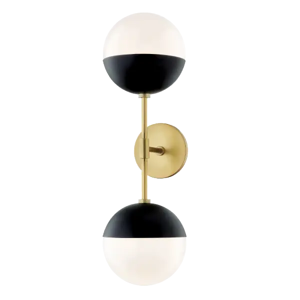 The Renee Wall Sconce combines aged brass warmth with black accents for a sophisticated look. Its compact design and glass globe shade make it perfect for bathrooms, hallways, and intimate spaces seeking refined illumination.