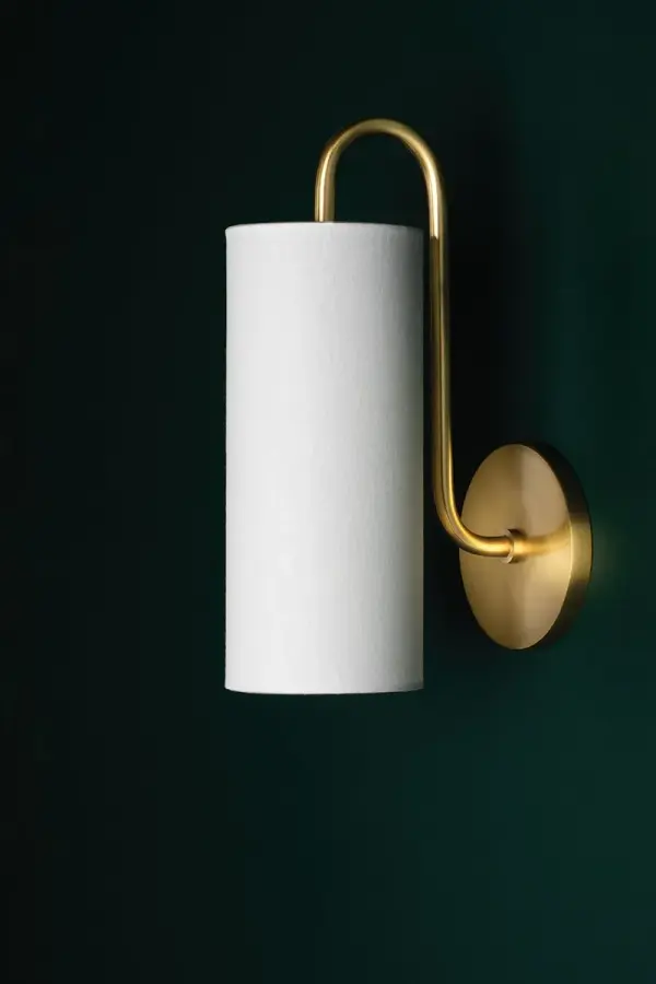 The Freda Wall Sconce combines classic elegance with contemporary simplicity. Its aged gold brass finish and glass globe shade create warm, inviting illumination perfect for intimate spaces and hallways. - alternate view