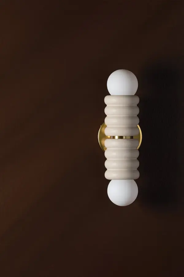 The Bibi Wall Sconce brings a unique sculptural presence with its stacked ceramic antique ivory pillows and aged brass accents. Inspired by upholstered furniture design, it offers a soft, contemporary aesthetic perfect for modern interiors. - alternate view