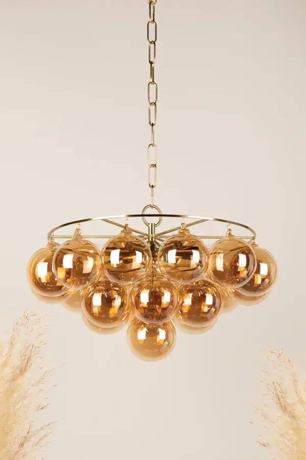 The Mimi Chandelier features swirl-ribbed champagne glass globes suspended from an Aged Brass frame, creating a sophisticated cloud-like effect. Part of the Megan Molten x Mitzi collaboration, it brings soft glamour to dining rooms, entryways, and breakfast nooks. - alternate view