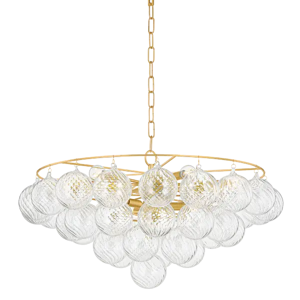 The Mimi Chandelier features swirl-ribbed champagne glass globes suspended from an Aged Brass frame, creating a sophisticated cloud-like effect. Part of the Megan Molten x Mitzi collaboration, this showstopper brings soft glamour to any space.