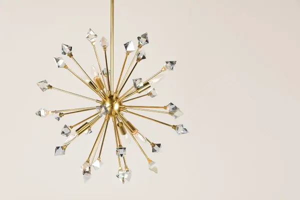 The Genesis Chandelier reimagines the classic sputnik design with iridescent crystals that create stunning light prisms. Its aged brass finish and starburst silhouette make it a statement piece for modern and transitional spaces. - alternate view