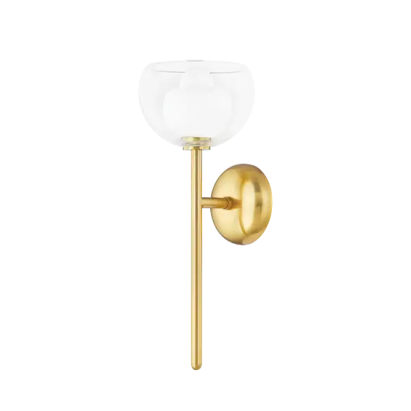 The Cortney Wall Sconce features a sophisticated double-glass design with an opal inner shade captured within clear glass, complemented by Aged Brass hardware. This trendy fixture offers beautiful light diffusion and reflection.