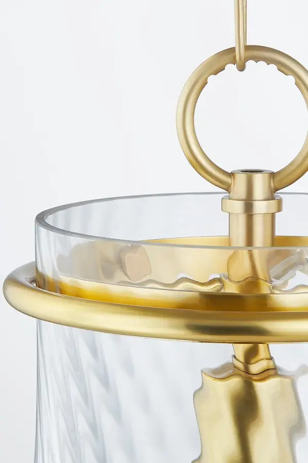 The Cantana Pendant blends traditional charm with modern sophistication through its clear optic glass shade featuring a distinctive swirl pattern. The aged brass metal ring adds warmth and visual interest while the swirled glass refracts light beautifully for a soft, ambient glow. - alternate view
