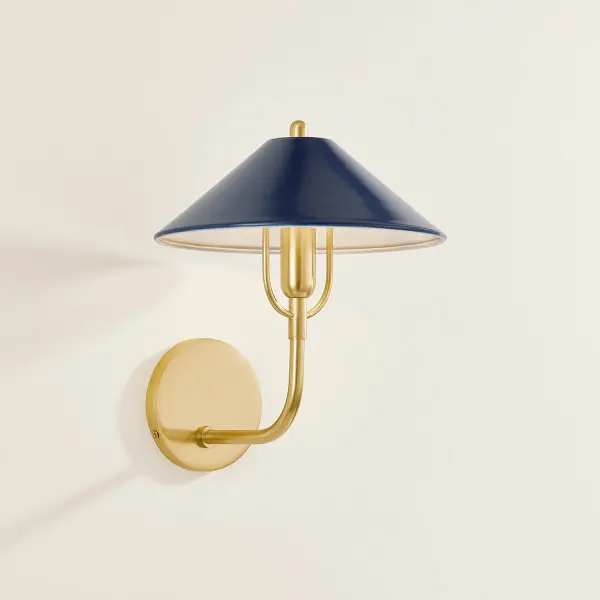 The Mariel Wall Sconce beautifully bridges traditional and modern design with its distinctive curved harp detail and sophisticated Aged Brass finish paired with a Soft Navy metal shade. Perfect for adding refined ambient lighting. - alternate view