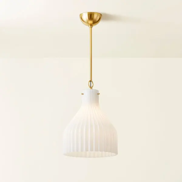The Corinthia Pendant brings sophisticated simplicity to any space with its gracefully ribbed opal glass shade and aged brass finish. Inspired by Greek design principles, this versatile fixture works beautifully solo or grouped for dramatic effect. - alternate view
