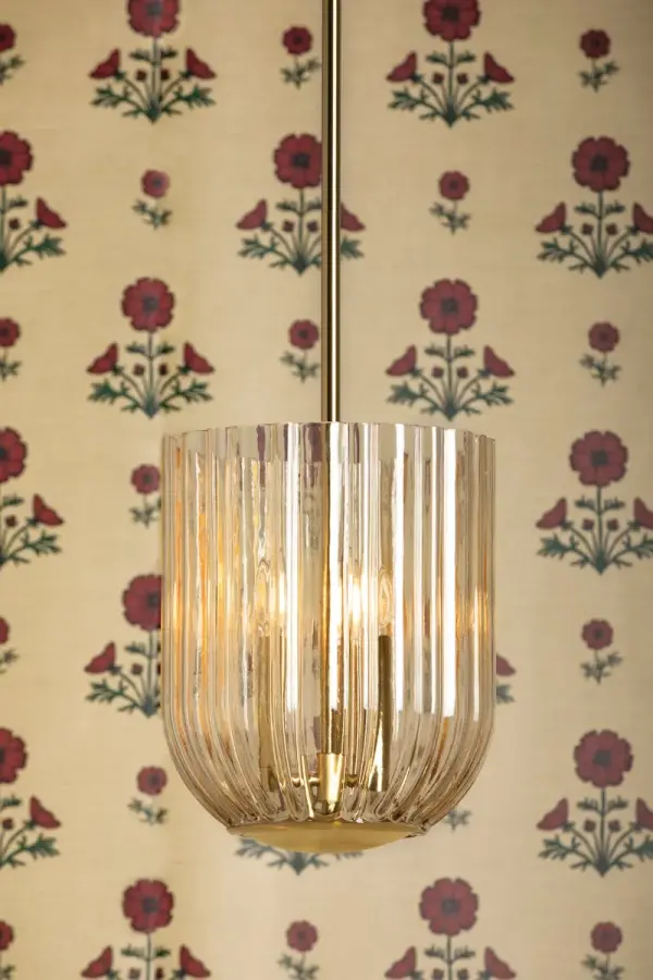 The Cece Lantern combines delicate scalloped champagne glass with warm Aged Brass accents to create a sophisticated focal point. Its floral-inspired design floods spaces with soft, radiant light while adding refined elegance. - alternate view