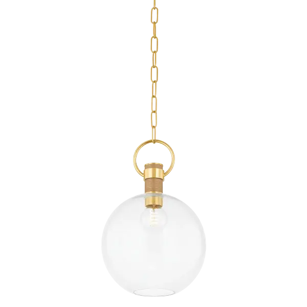 The Catrine Pendant masterfully blends industrial design with organic elements, featuring a large glass globe suspended by an oversized pin and loop in Aged Brass, softened by natural grass cloth wrapping for textural interest.