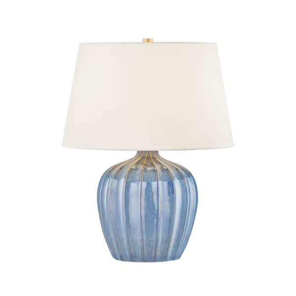 The petite Myla brings coastal charm with its Spring Lake reactive glaze and vertical ribbing. Perfect for bedside use, this accent lamp combines playful design with sophisticated Aged Brass hardware and a crisp white linen shade.